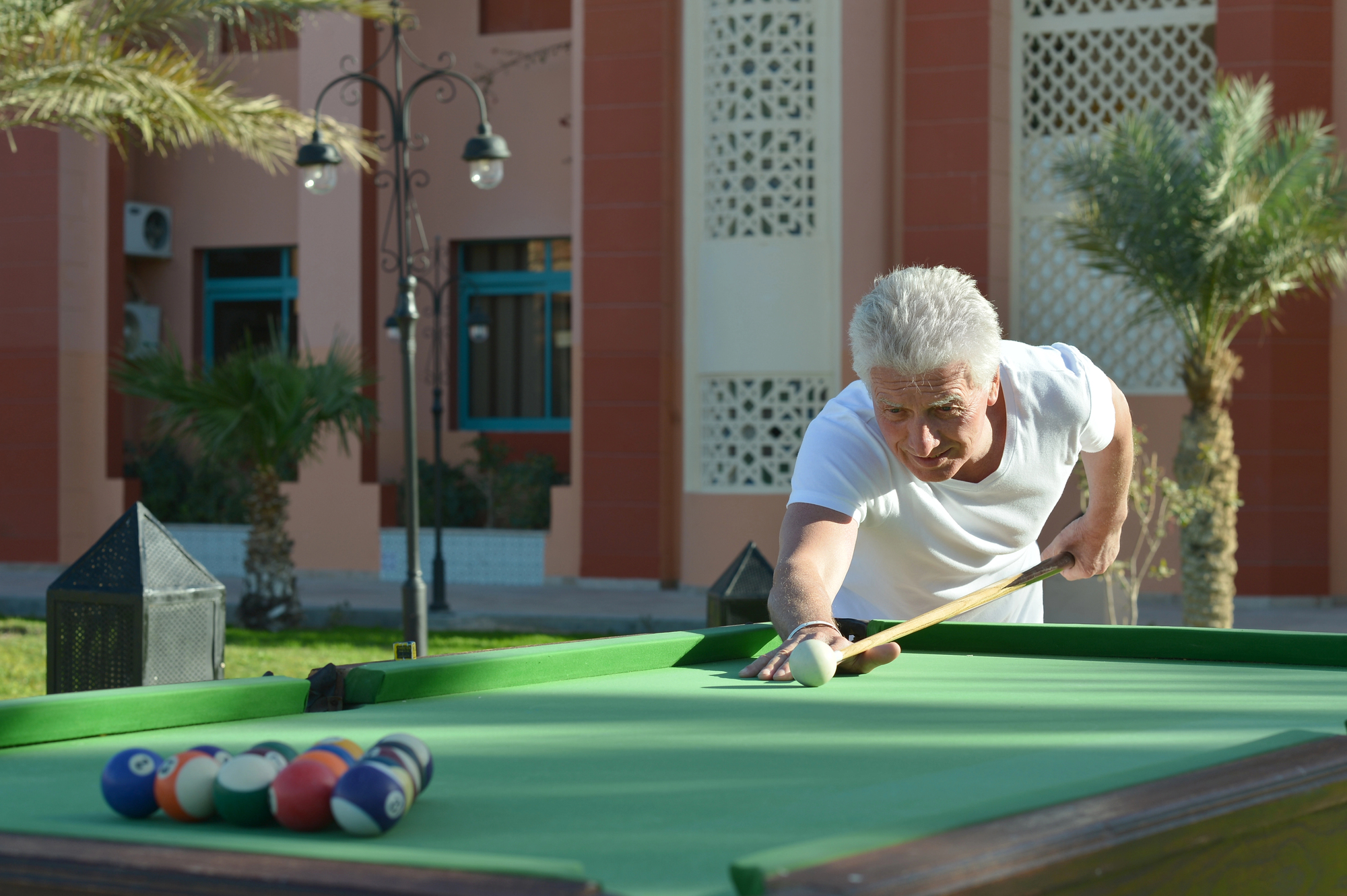 man playing a game pool on an outdoor pool table