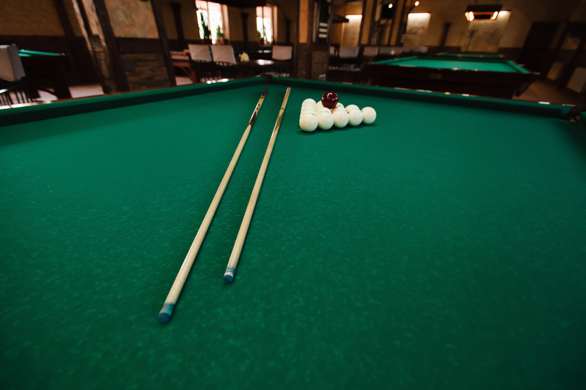 Billiard balls and pool cue on green table